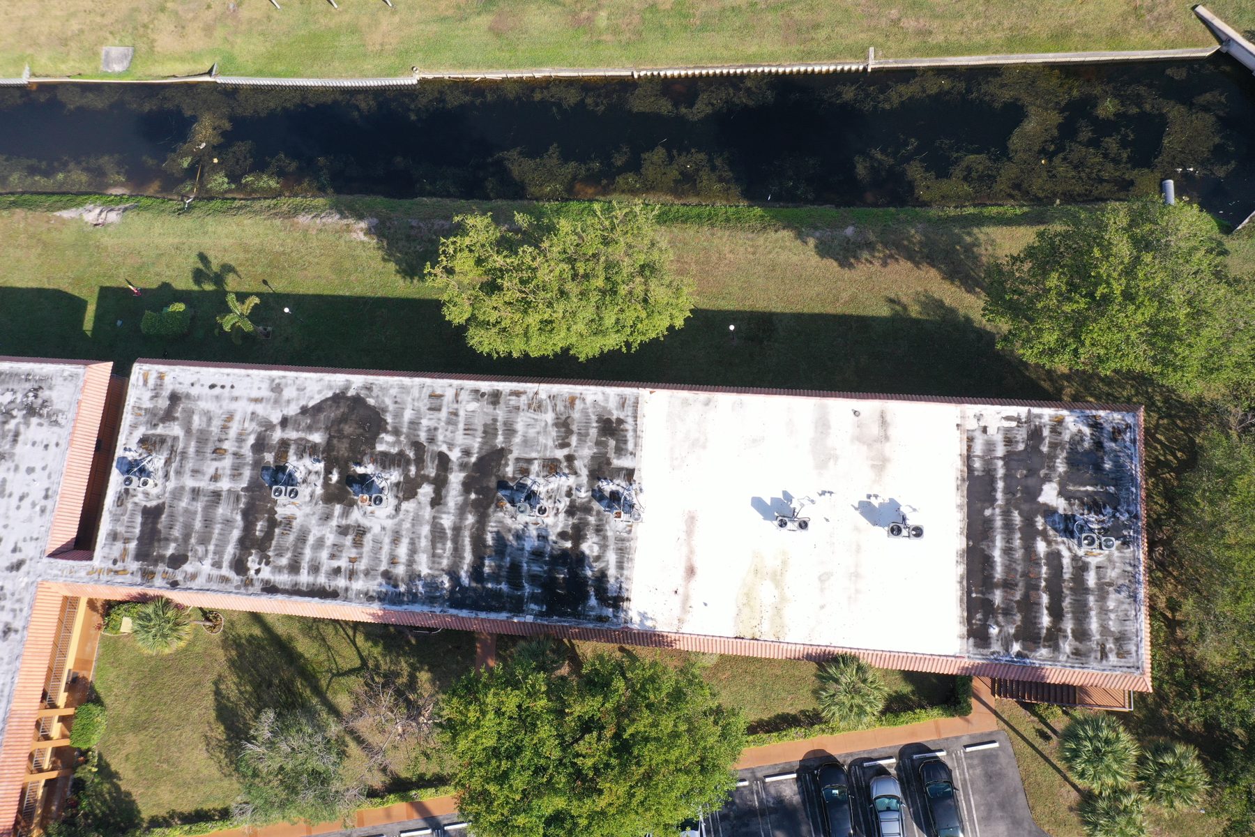 Aerial view of a managed-building roof, HVAC, and parking.